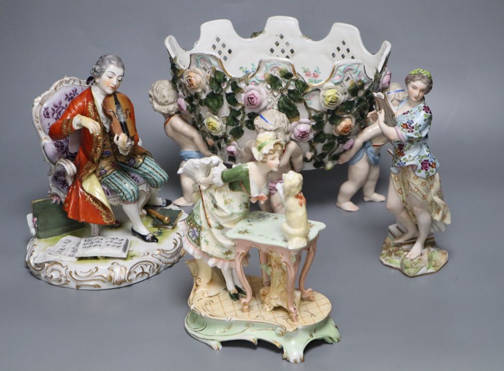 A Meissen style flower-encrusted reticulated oval porcelain jardiniere with cherub supports and three other items,